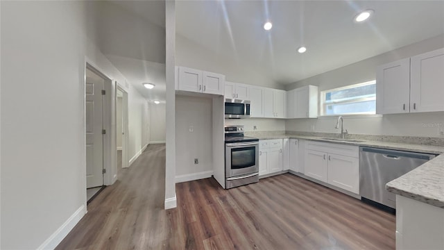 kitchen with white cabinetry, appliances with stainless steel finishes, sink, and hardwood / wood-style floors