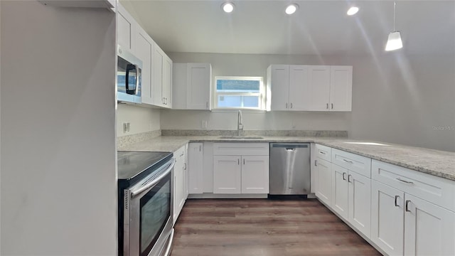 kitchen with stainless steel appliances, decorative light fixtures, sink, and white cabinets