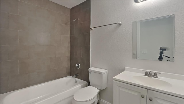 full bathroom featuring vanity, tiled shower / bath, and toilet