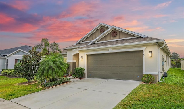 view of front of property with a garage and a lawn