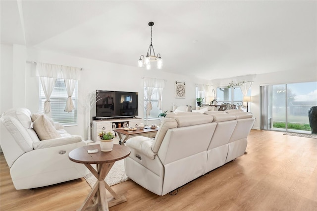 living room with an inviting chandelier and light wood-type flooring