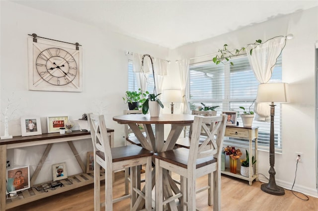 dining space with wood-type flooring