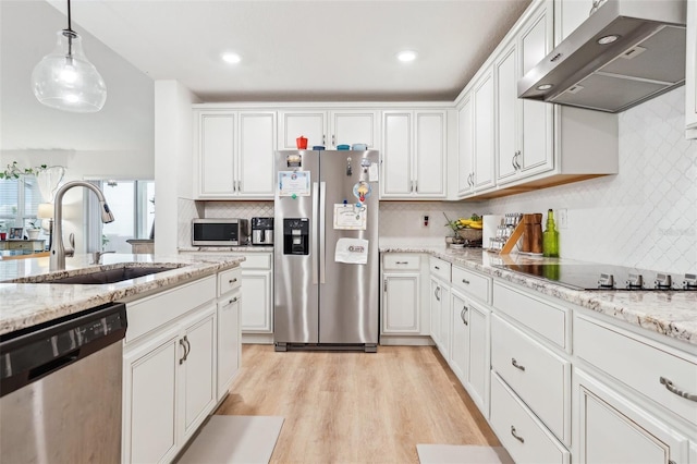 kitchen featuring sink, decorative light fixtures, appliances with stainless steel finishes, light hardwood / wood-style floors, and white cabinets