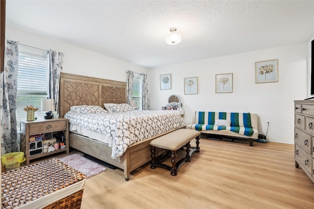 bedroom featuring a textured ceiling and light wood-type flooring