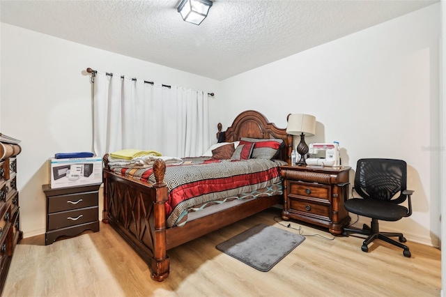 bedroom with light hardwood / wood-style flooring and a textured ceiling