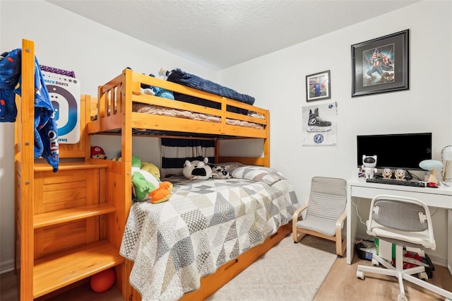 bedroom featuring light hardwood / wood-style floors and a textured ceiling