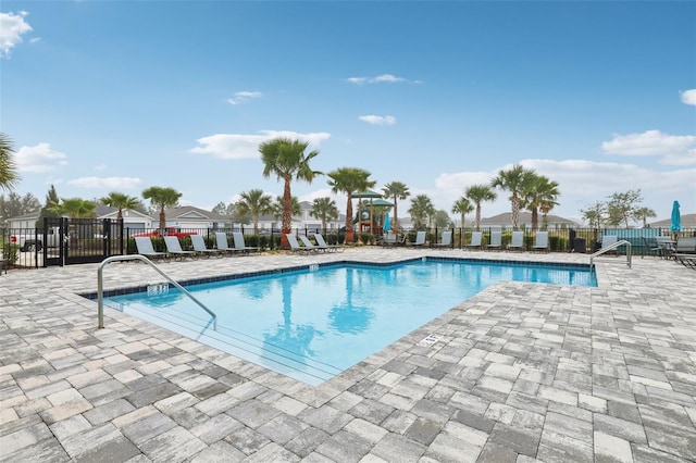 view of pool featuring a playground and a patio area