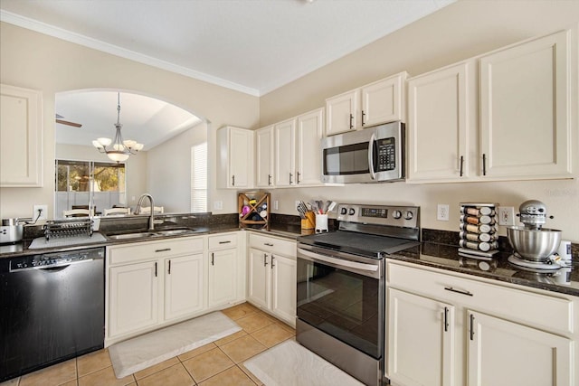 kitchen with sink, white cabinetry, stainless steel appliances, decorative light fixtures, and dark stone counters