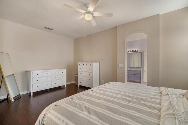 bedroom with ceiling fan, connected bathroom, and dark hardwood / wood-style flooring