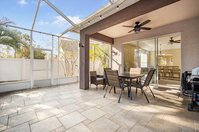 sunroom with ceiling fan and beamed ceiling