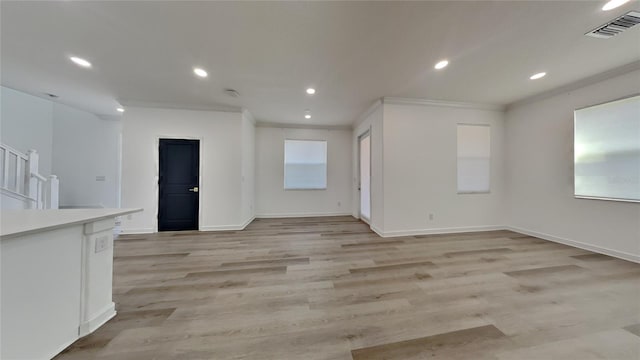 unfurnished living room featuring crown molding and light hardwood / wood-style floors