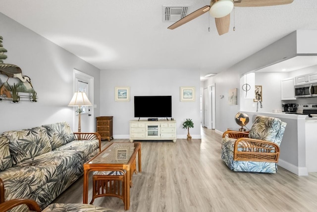 living room featuring light hardwood / wood-style flooring and ceiling fan