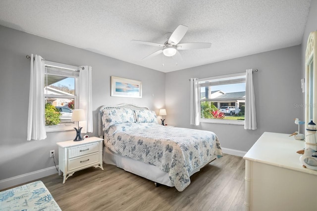 bedroom with hardwood / wood-style flooring, ceiling fan, and a textured ceiling