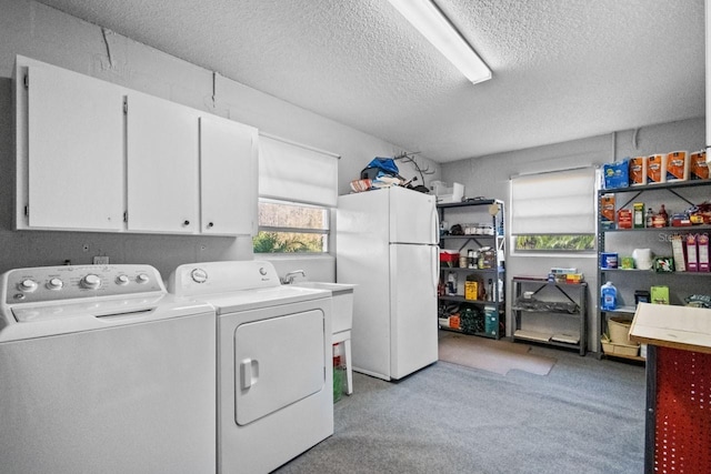 washroom with cabinets, a textured ceiling, and independent washer and dryer