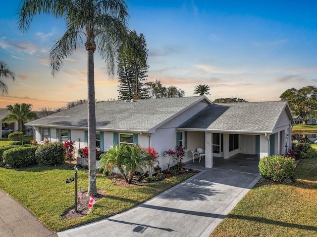 ranch-style home with a carport and a lawn