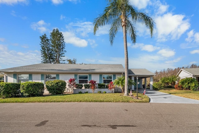 ranch-style home featuring a front yard and a carport