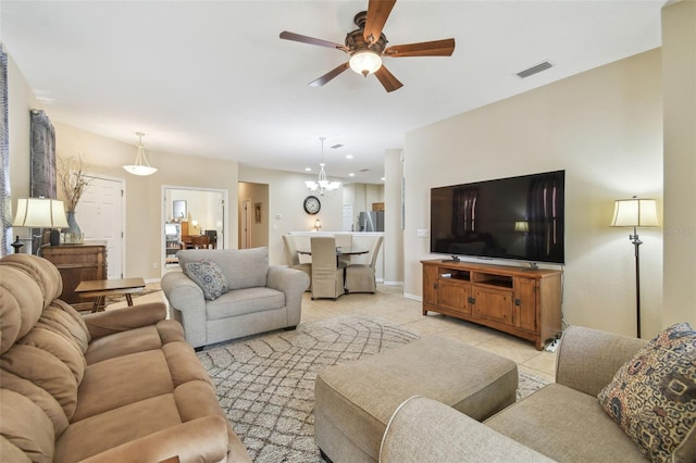 tiled living room featuring ceiling fan with notable chandelier