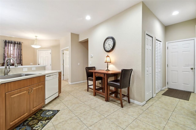 kitchen with pendant lighting, white dishwasher, sink, and light tile patterned floors