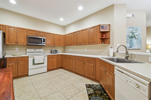 kitchen with white appliances, sink, and light tile patterned floors