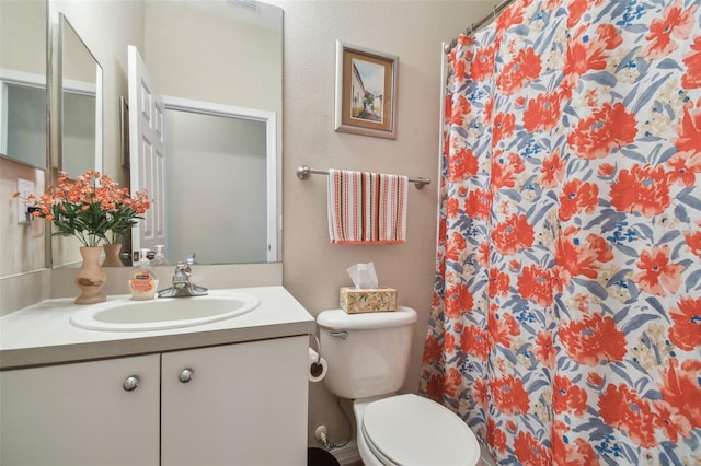 bathroom featuring a shower with curtain, vanity, and toilet