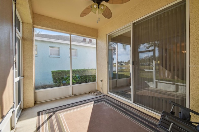 unfurnished sunroom featuring ceiling fan