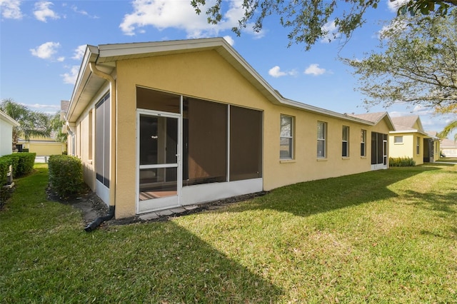 rear view of property with a sunroom and a lawn