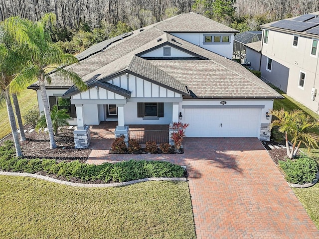 view of front of home with a garage, decorative driveway, a shingled roof, and board and batten siding