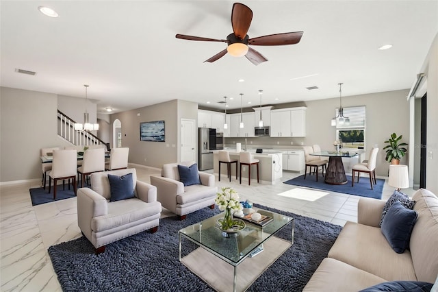 living room with recessed lighting, marble finish floor, visible vents, and stairway