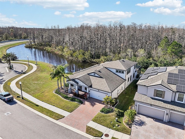 aerial view with a water view and a wooded view