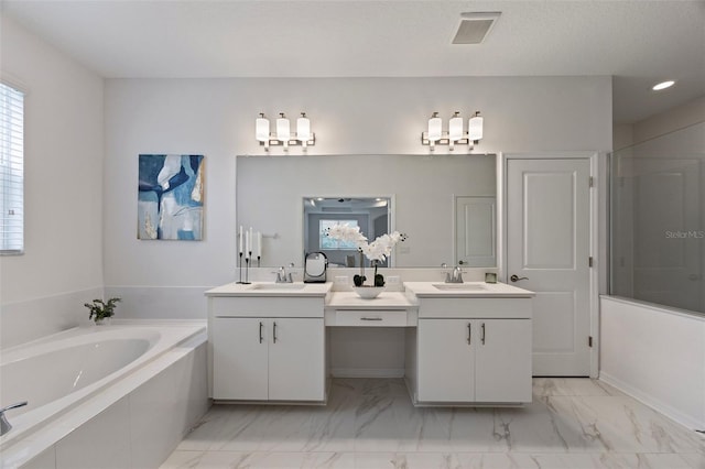 full bathroom with a garden tub, visible vents, two vanities, and a sink