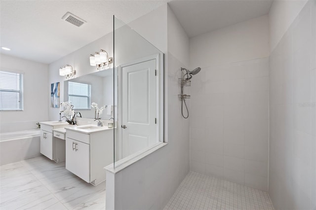 bathroom with visible vents, a garden tub, marble finish floor, a tile shower, and vanity