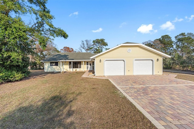 single story home with a garage and a front lawn