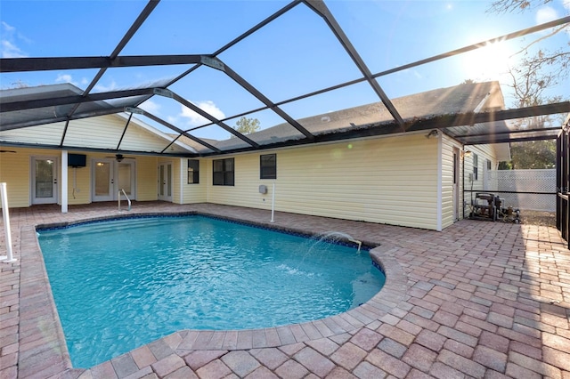 view of pool with ceiling fan, a lanai, pool water feature, and a patio area