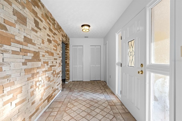 doorway to outside featuring a textured ceiling