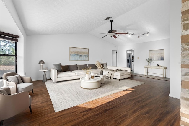 living room featuring lofted ceiling, ceiling fan, dark hardwood / wood-style flooring, and a textured ceiling