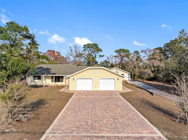 ranch-style house featuring a garage and a front lawn