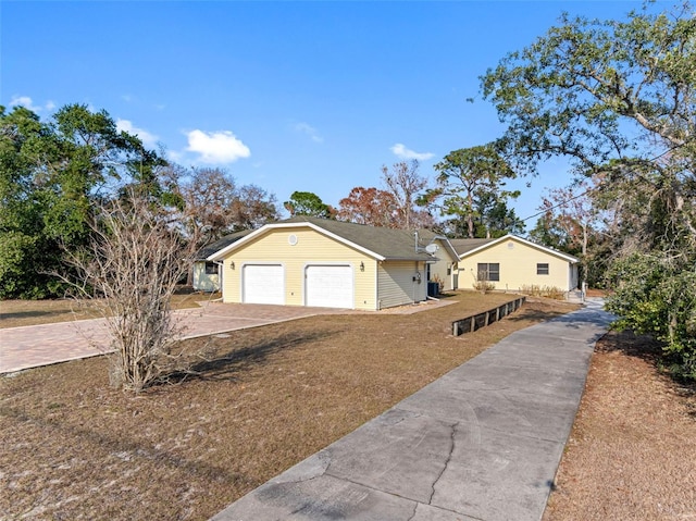 single story home featuring a garage and a front lawn