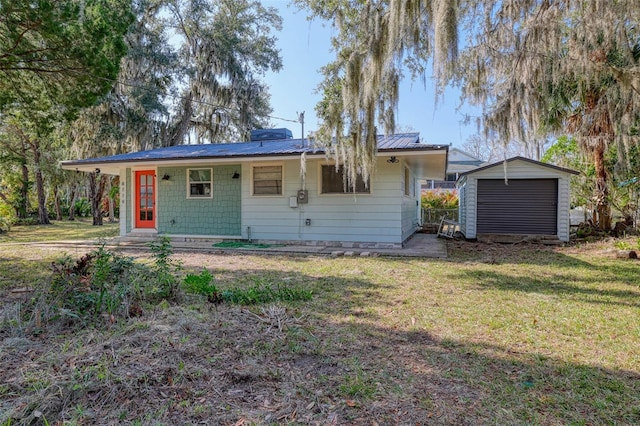 view of front of house featuring an outbuilding, a garage, and a front yard