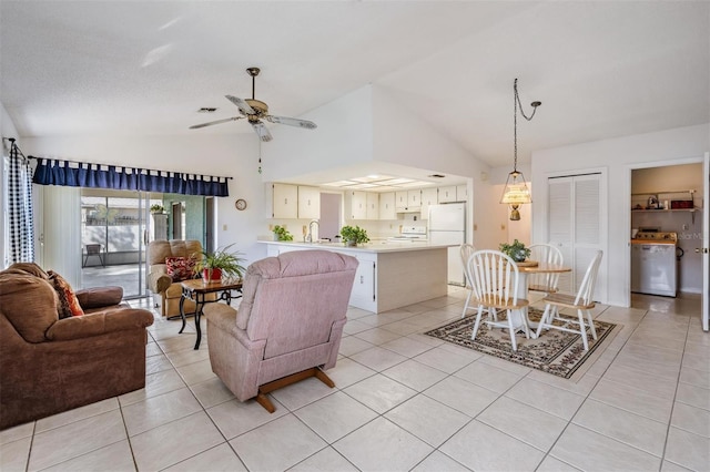 living room with lofted ceiling, sink, light tile patterned floors, and ceiling fan