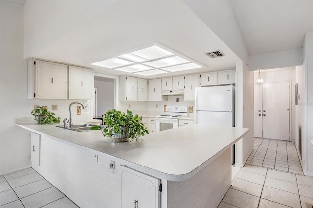 kitchen with sink, white appliances, kitchen peninsula, and light tile patterned floors