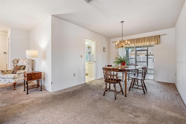 carpeted dining room with a notable chandelier and a textured ceiling