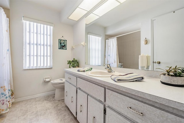 bathroom featuring vanity, toilet, and a skylight