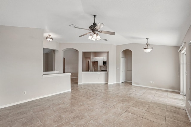 unfurnished living room with vaulted ceiling, light tile patterned floors, and ceiling fan