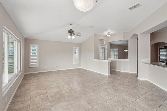 unfurnished living room with lofted ceiling, ceiling fan, and light tile patterned flooring