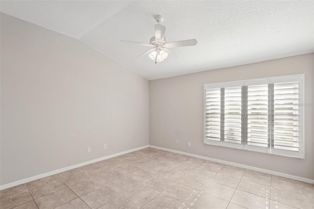 tiled empty room featuring lofted ceiling, a textured ceiling, and ceiling fan