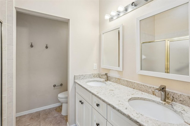 bathroom with tile patterned flooring, vanity, a shower with door, and toilet