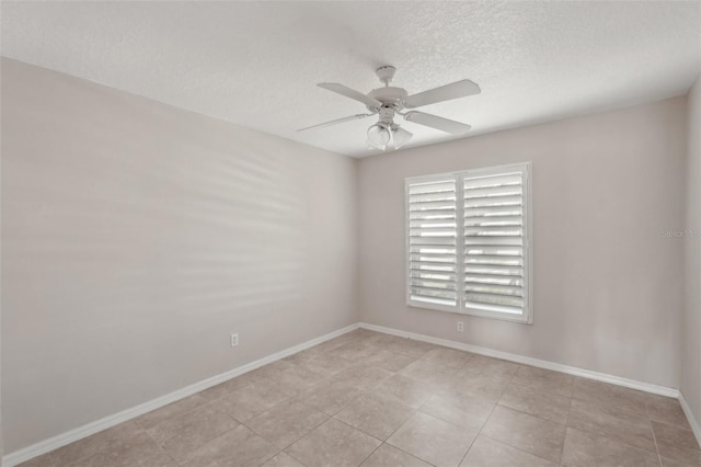 unfurnished room with ceiling fan and a textured ceiling