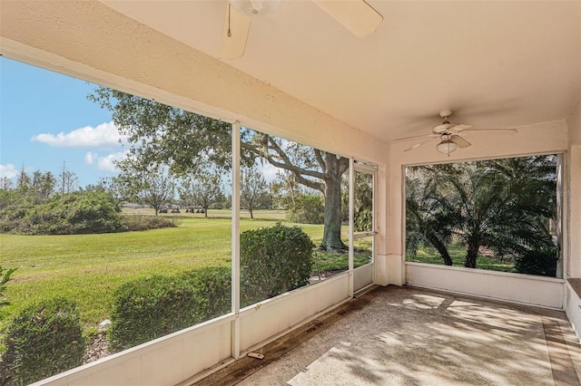 unfurnished sunroom featuring ceiling fan