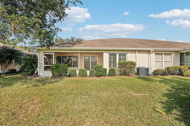 single story home featuring cooling unit and a front lawn