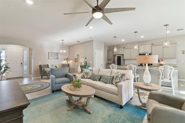 living room with ceiling fan with notable chandelier